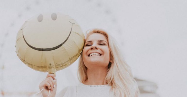 Positivity - Woman Holding a Smiley Balloon